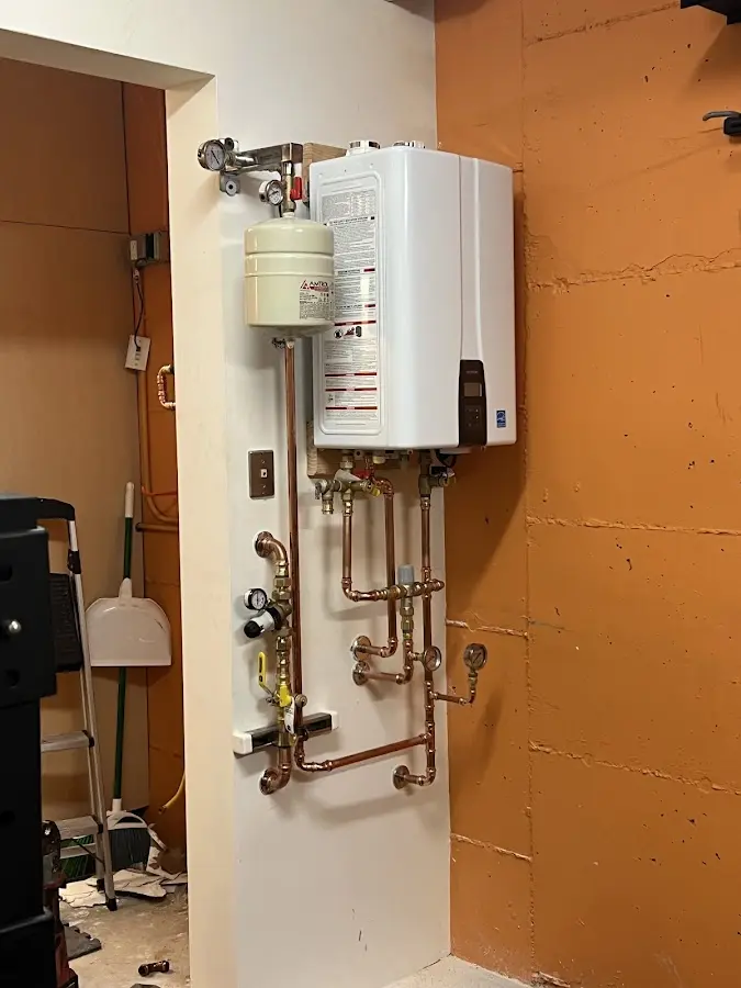 Plumbing technician inspecting water heater connections in Beckett Ridge